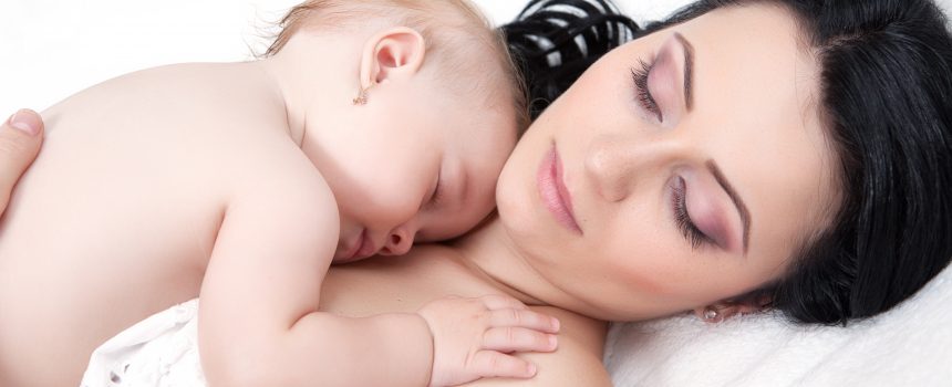 Young mother and her baby, sleeping in bed